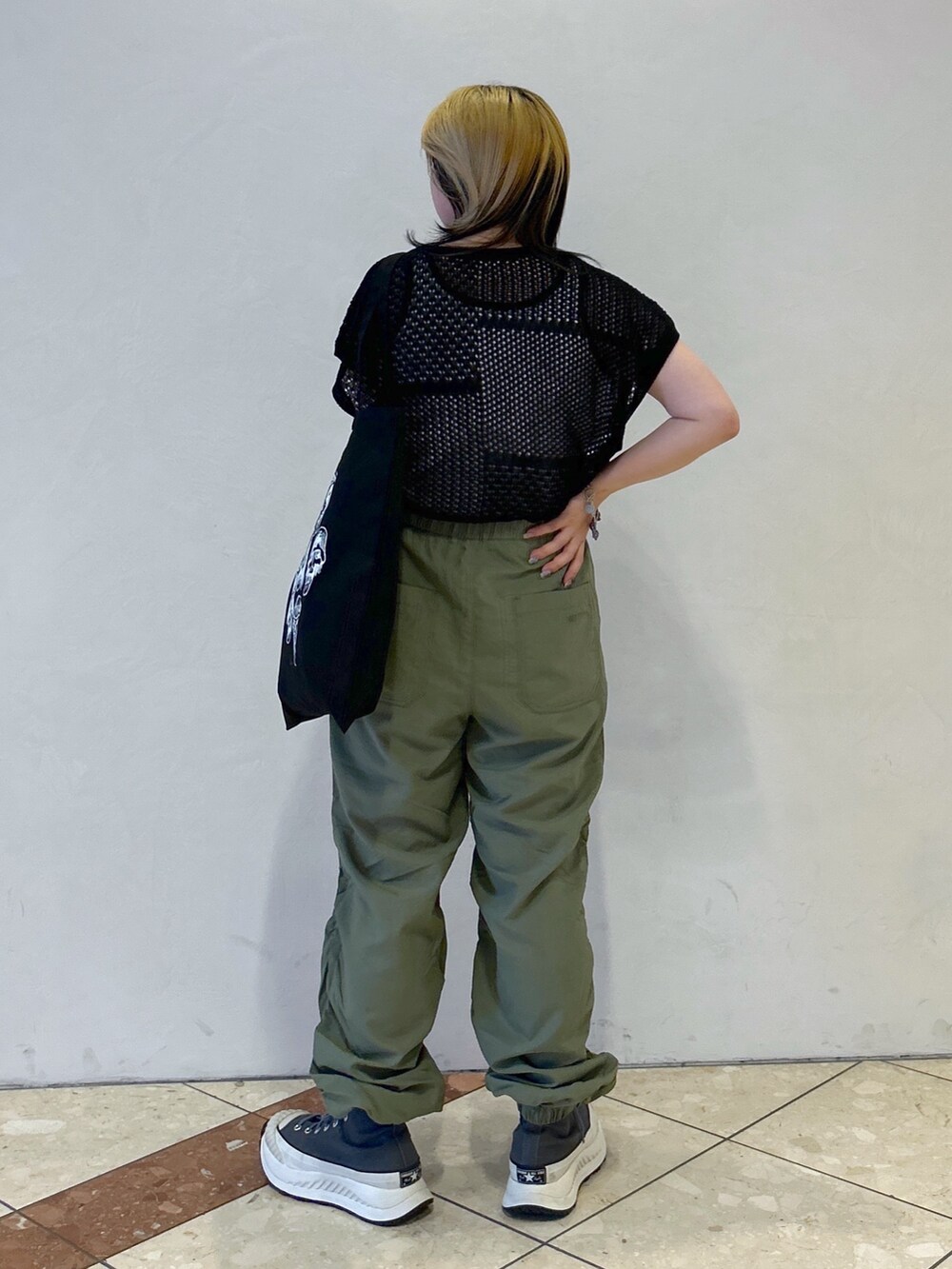 グリーン系のその他パンツ、ブラック系のTシャツ/カットソー、ホワイト系のタンクトップを着用したレディースの春コーディネートの2枚目の写真