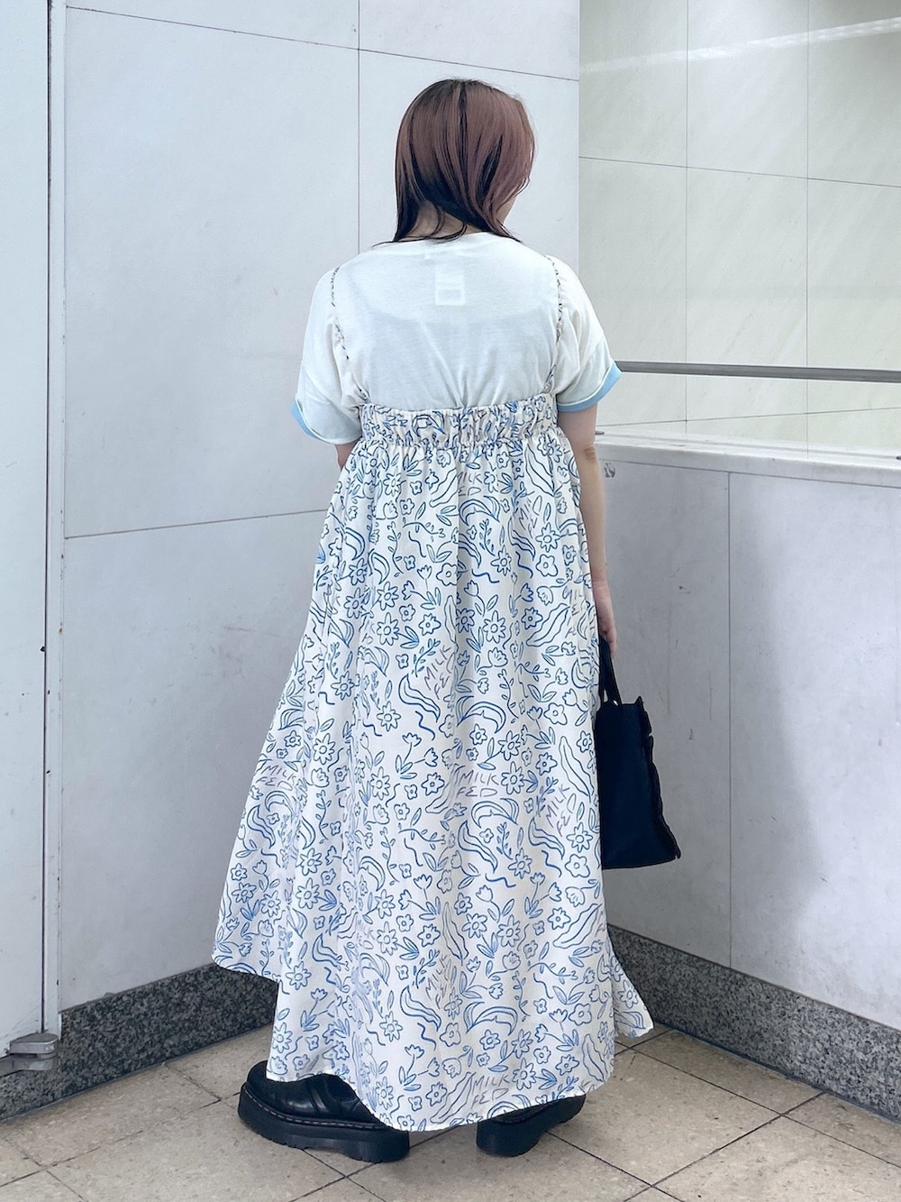 ホワイト系のワンピース、ブラック系のショルダーバッグ、ブラック系のブーツを着用したレディースの夏コーディネートの3枚目の写真