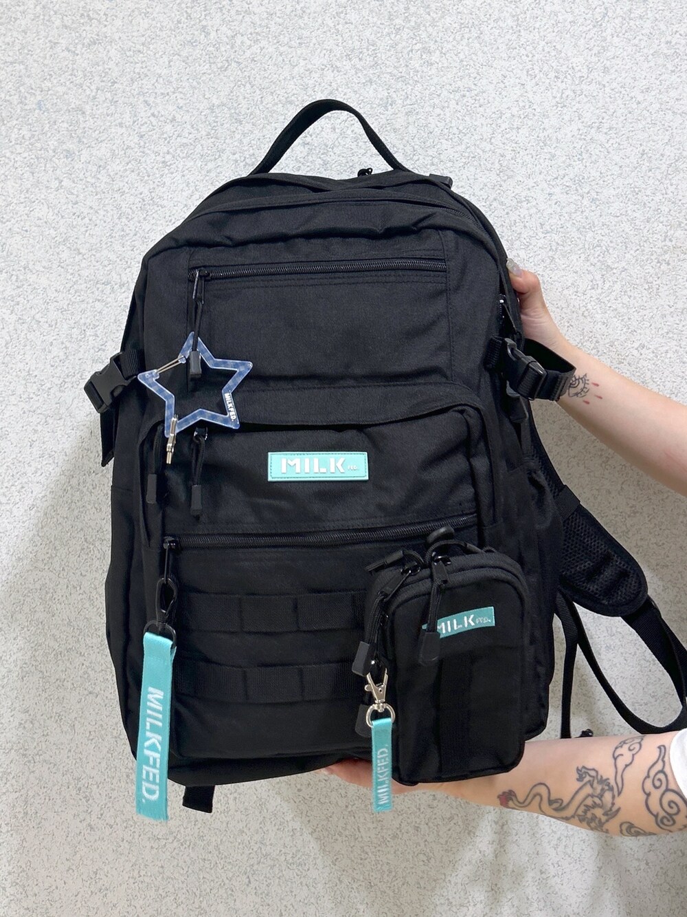 ホワイト系のTシャツ/カットソー、ブルー系のデニムスカート、グリーン系のバックパック/リュックを着用したレディースの春コーディネートの6枚目の写真