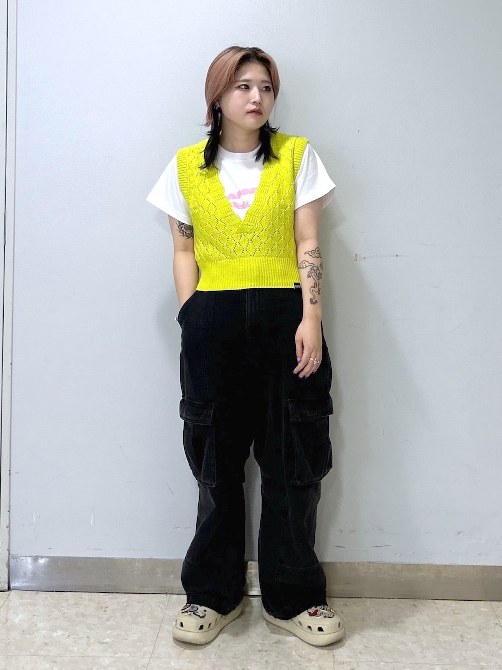 ホワイト系のTシャツ/カットソー、イエロー系のベスト、ブラック系のカーゴパンツを着用したレディースの夏コーディネートの3枚目の写真