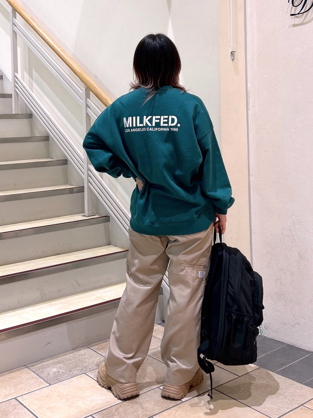 グリーン系のスウェット、ベージュ系のその他パンツ、ベージュ系のスニーカーを着用したレディースの夏コーディネートの4枚目の写真