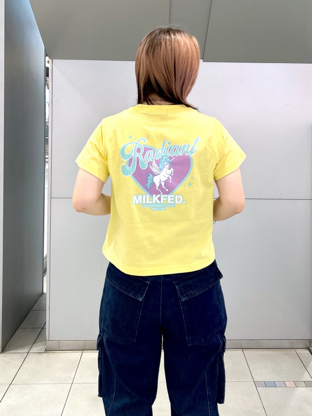 イエロー系のTシャツ/カットソー、ブラック系のキャミソール、ブラック系のブーツを着用したレディースの夏コーディネートの10枚目の写真