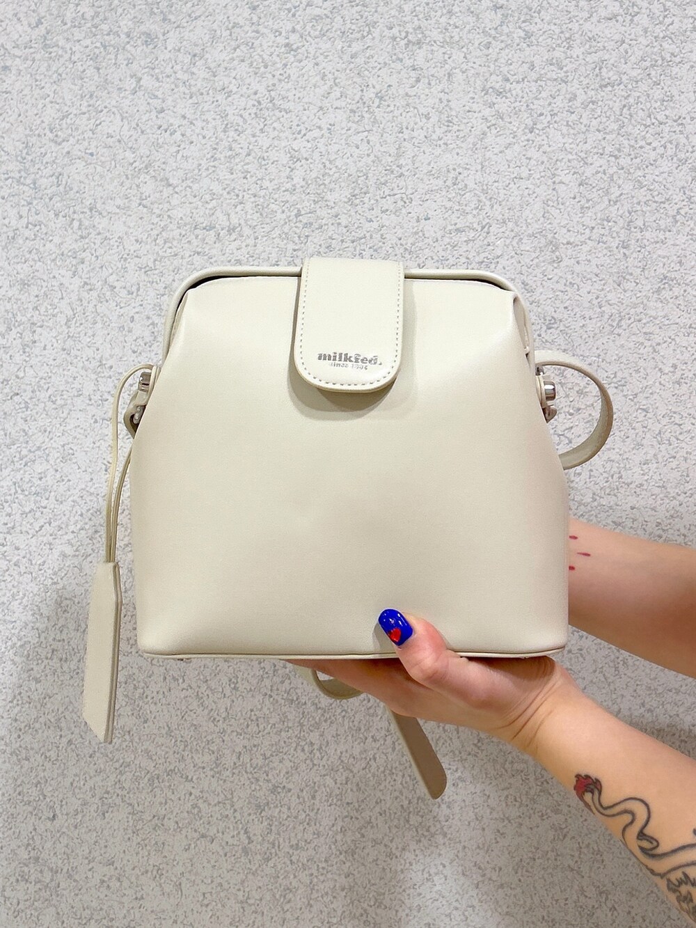 ピンク系のTシャツ/カットソー、ブラック系のデニムパンツ、ホワイト系のスカートを着用したレディースの春コーディネートの5枚目の写真