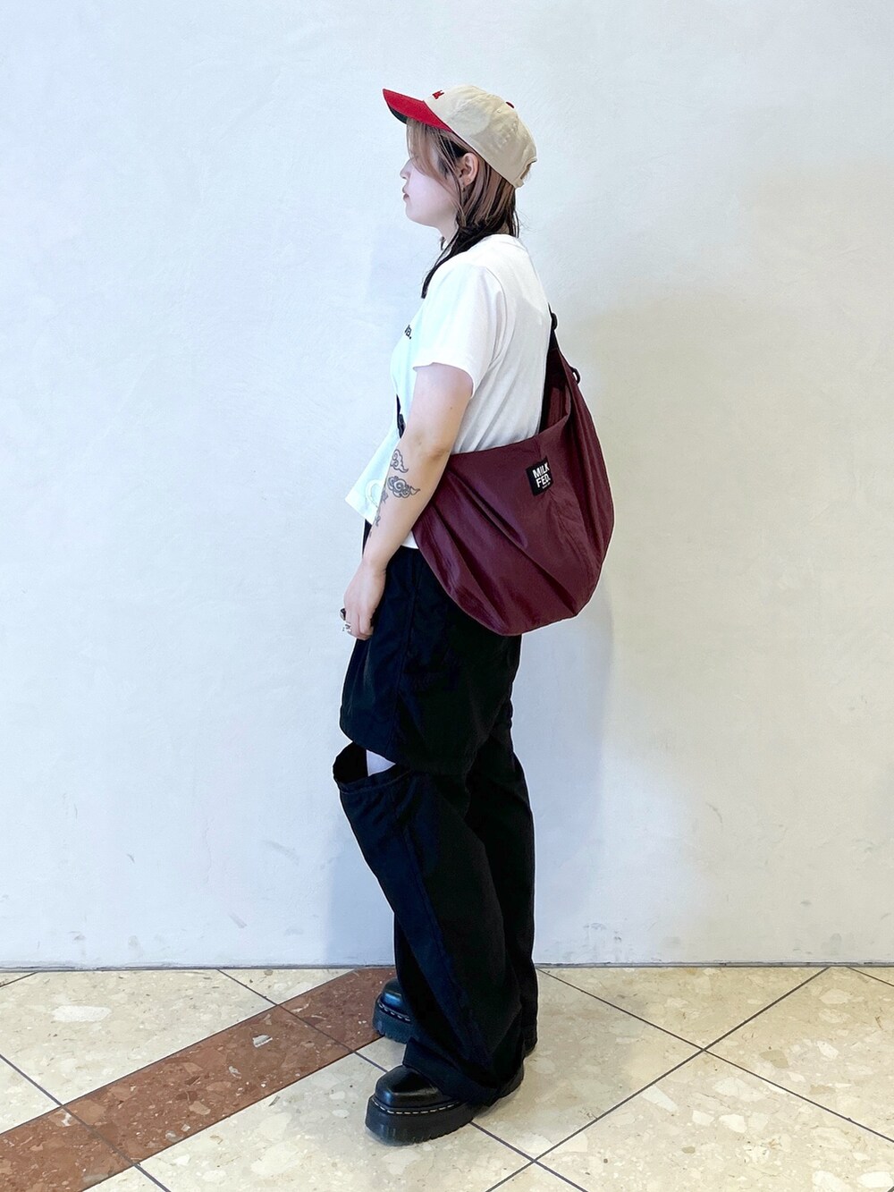 ブラック系のその他パンツ、レッド系のショルダーバッグ、ホワイト系のTシャツ/カットソーを着用したレディースの夏コーディネートの4枚目の写真