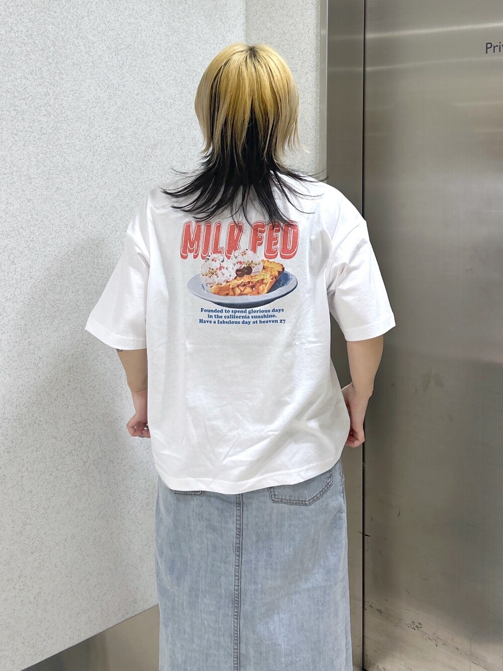 ホワイト系のTシャツ/カットソー、ブラック系のメッセンジャーバッグ、ブルー系のデニムスカートを着用したレディースの春コーディネートの6枚目の写真