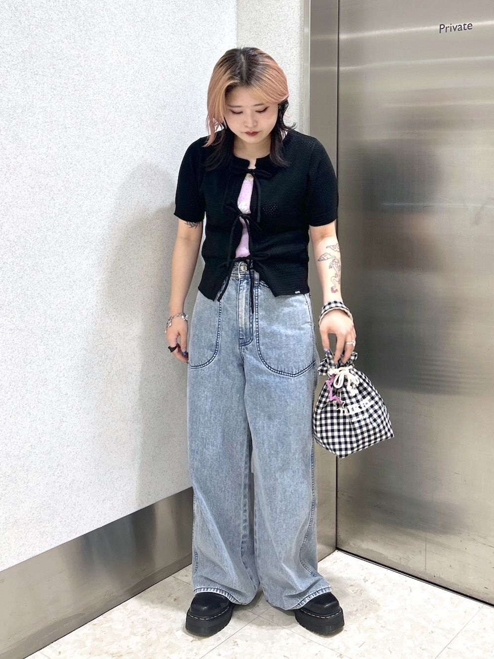 ブルー系のデニムパンツ、パープル系のタンクトップ、ブラック系のカーディガン/ボレロを着用したレディースの夏コーディネートの3枚目の写真