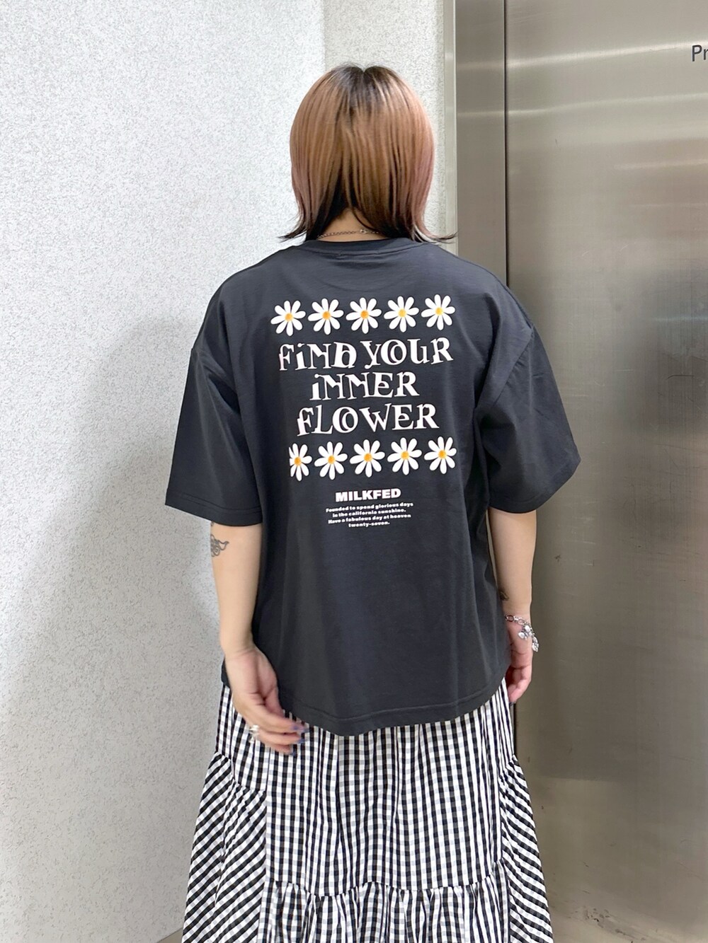 グレー系のTシャツ/カットソー、ブラック系のスカート、ホワイト系のショルダーバッグを着用したレディースの夏コーディネートの3枚目の写真