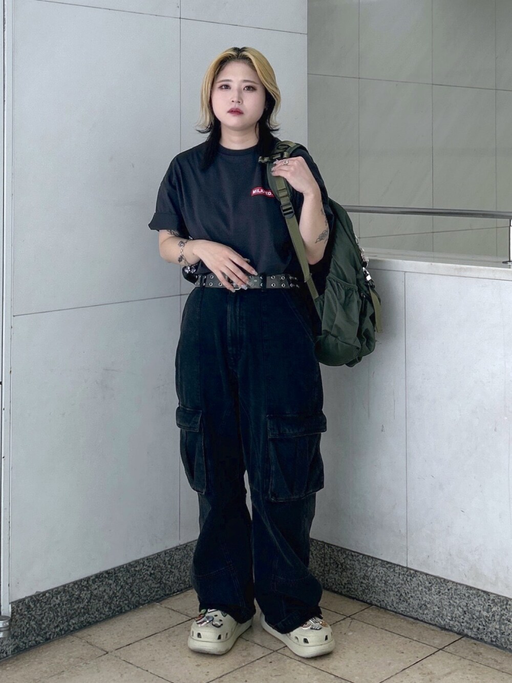 グレー系のTシャツ/カットソー、グリーン系のバックパック/リュック、ブラック系のカーゴパンツを着用したレディースの春コーディネートの4枚目の写真