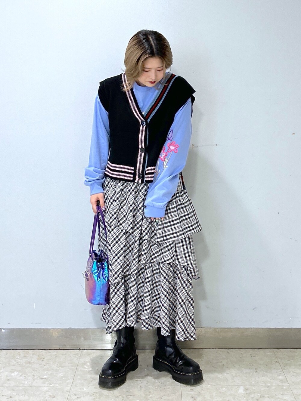 ブラック系のベスト、ブルー系のTシャツ/カットソー、ブラック系のスカートを着用したレディースの冬コーディネートの3枚目の写真