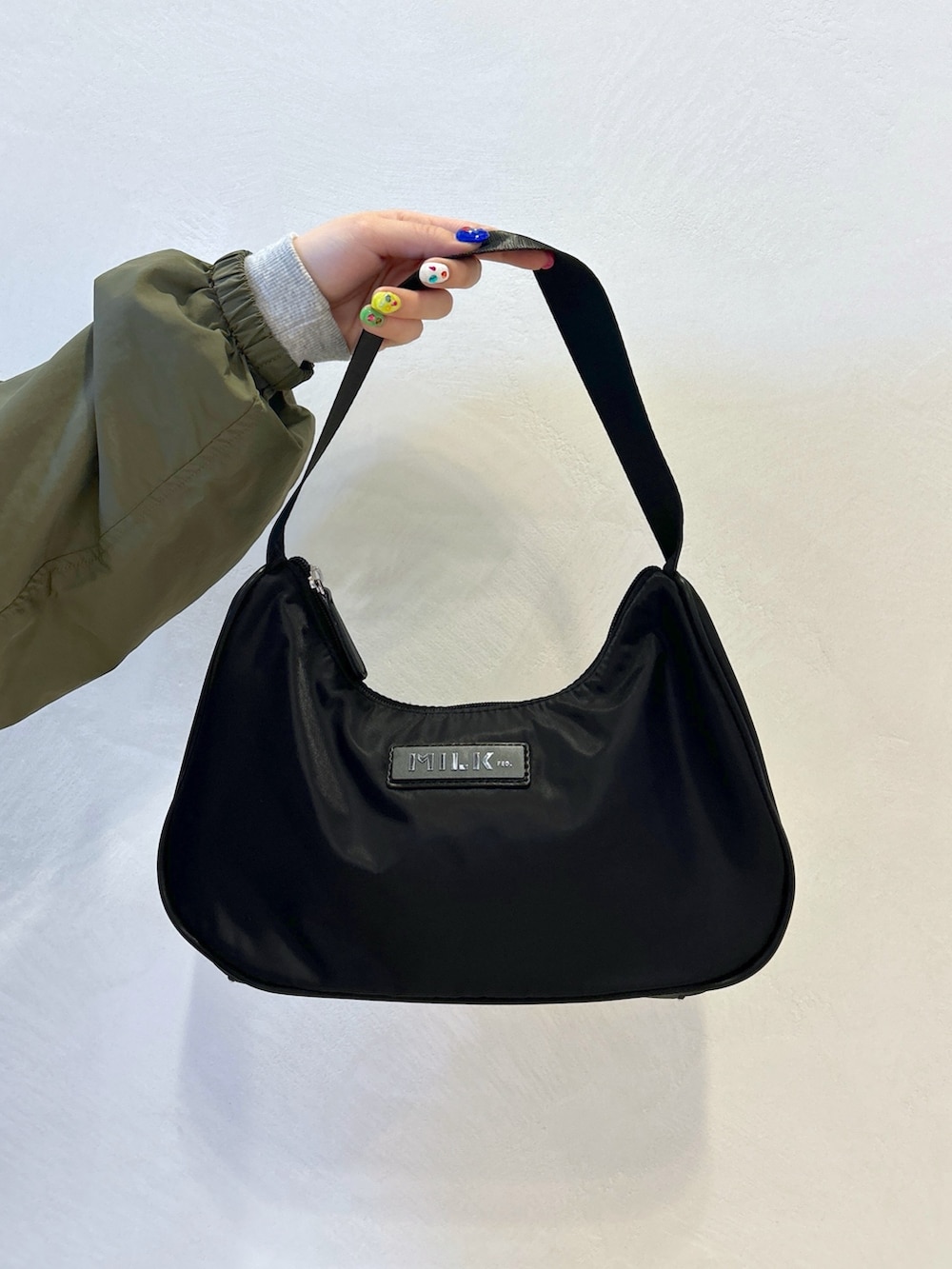 グレー系のTシャツ/カットソー、ベージュ系のナイロンジャケット、ブラック系のサロペット/オーバーオールを着用したレディースの春コーディネートの8枚目の写真