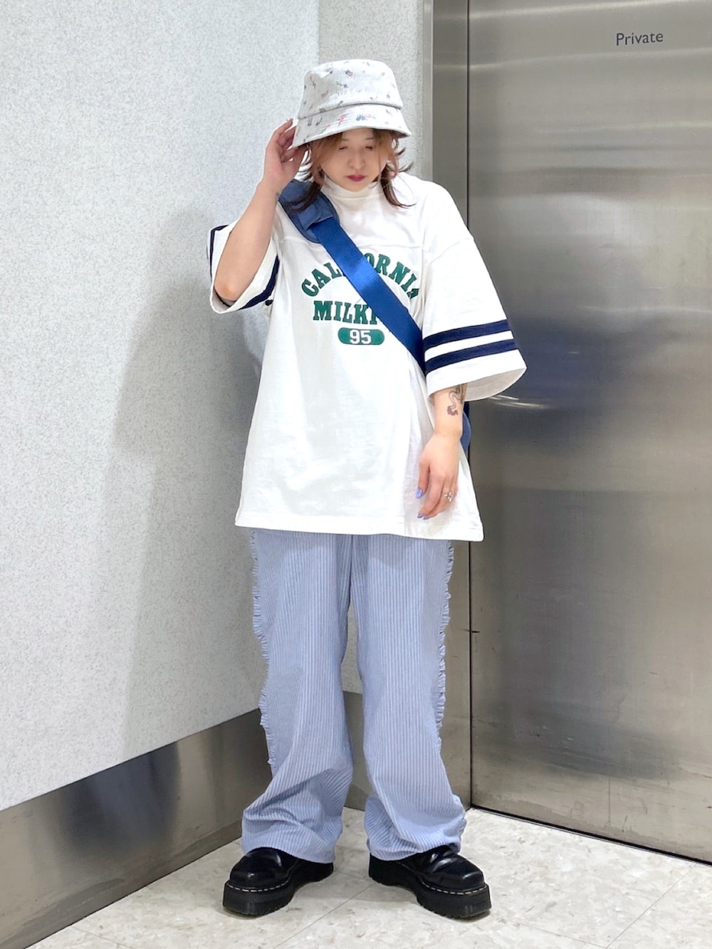 ブルー系のメッセンジャーバッグ、ホワイト系のTシャツ/カットソー、ブルー系のその他パンツを着用したレディースの春コーディネートの2枚目の写真