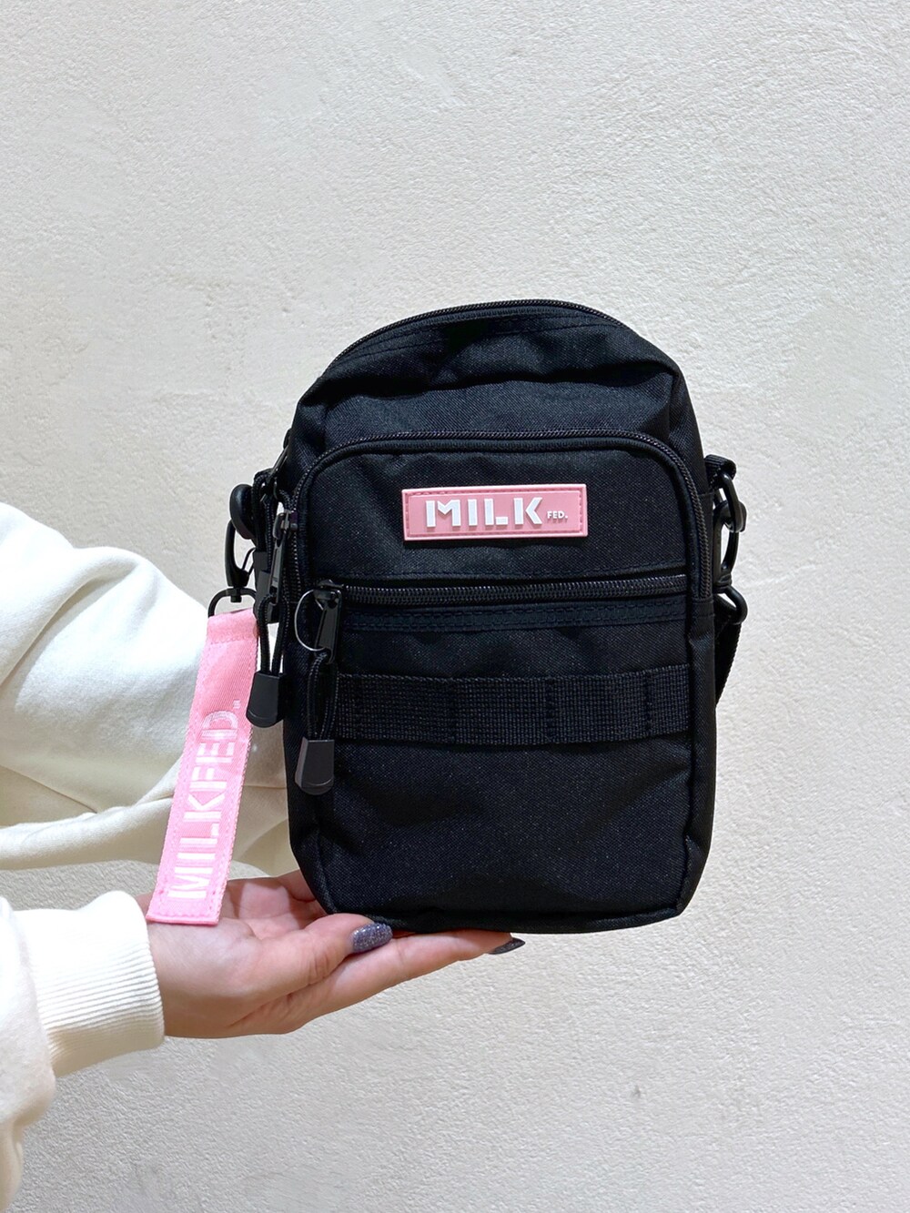 ホワイト系のパーカー、ピンク系のショルダーバッグ、グレー系のワンピースを着用したレディースの秋コーディネートの4枚目の写真