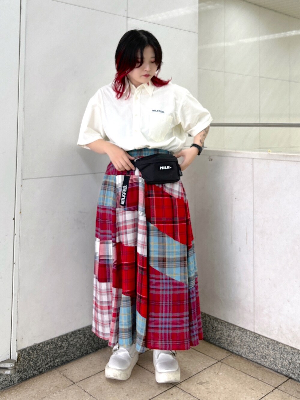 ホワイト系のシャツ/ブラウス、ブラック系のボディバッグ/ウエストポーチ、レッド系のスカートを着用したレディースの夏コーディネートの2枚目の写真