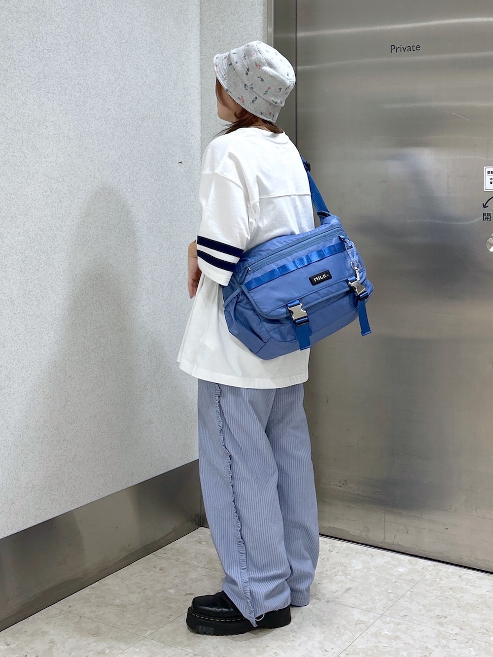 ブルー系のメッセンジャーバッグ、ホワイト系のTシャツ/カットソー、ブルー系のその他パンツを着用したレディースの春コーディネートの4枚目の写真