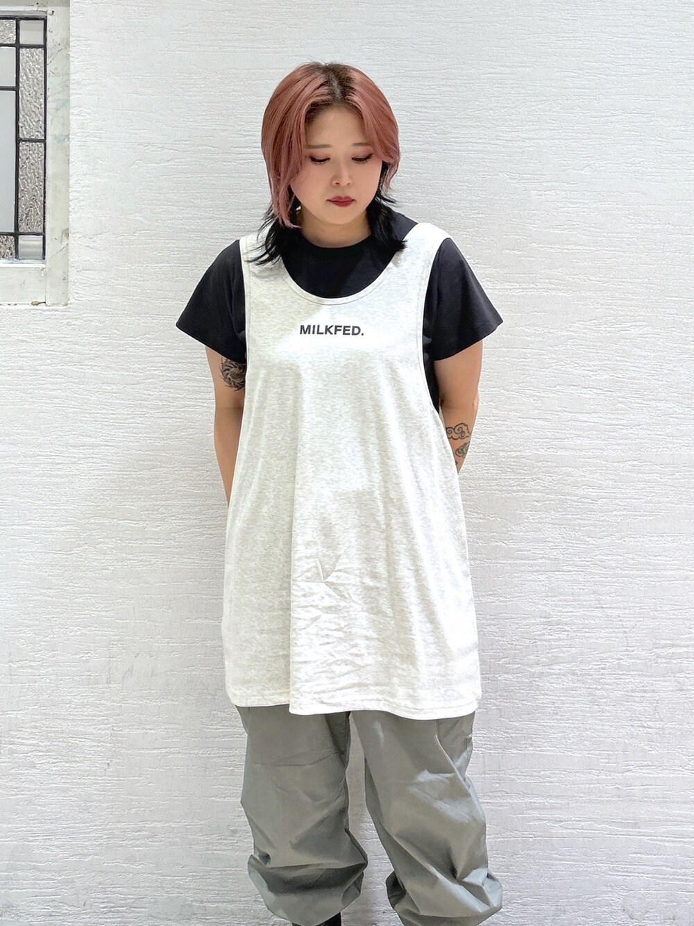 グレー系のTシャツ/カットソー、グリーン系のショルダーバッグ、ベージュ系のタンクトップを着用したレディースの春コーディネートの5枚目の写真