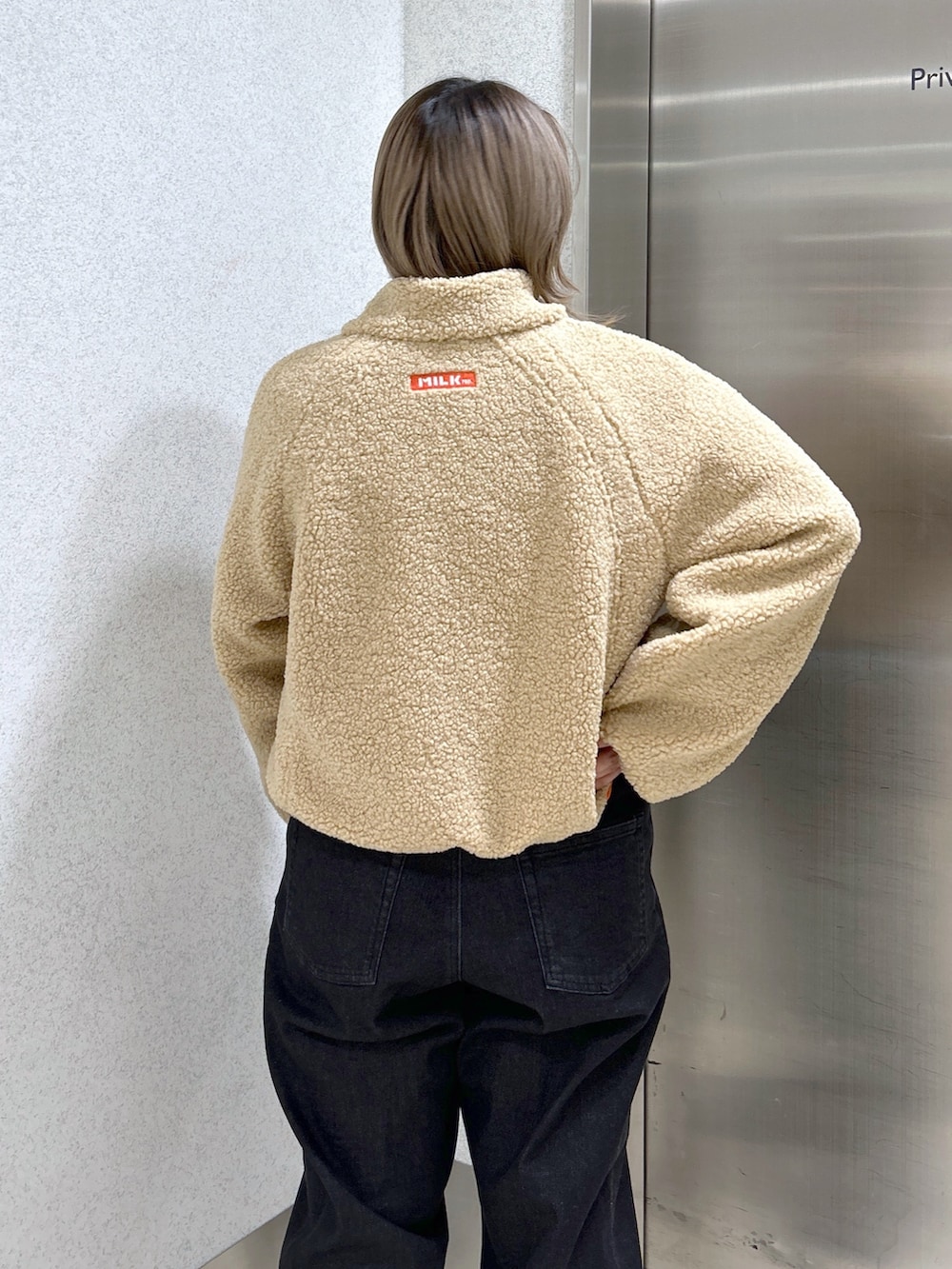 ピンク系のボディバッグ/ウエストポーチ、ピンク系のTシャツ/カットソー、ベージュ系のブルゾンを着用したレディースの冬コーディネートの2枚目の写真