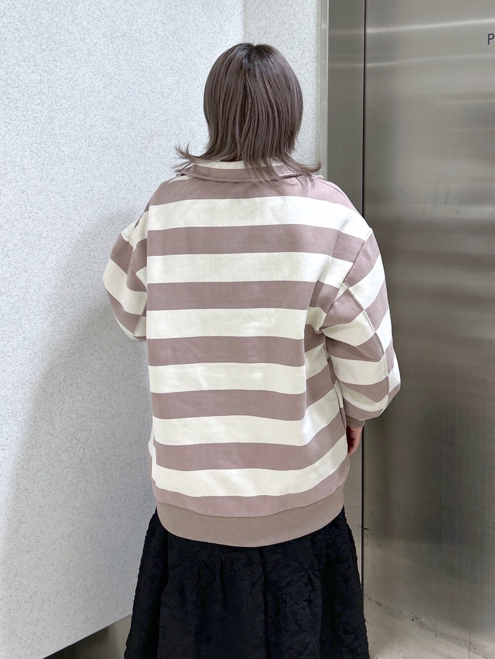 グレー系のスウェット、ブラック系のワンピース、ブラック系のブーツを着用したレディースの冬コーディネートの4枚目の写真