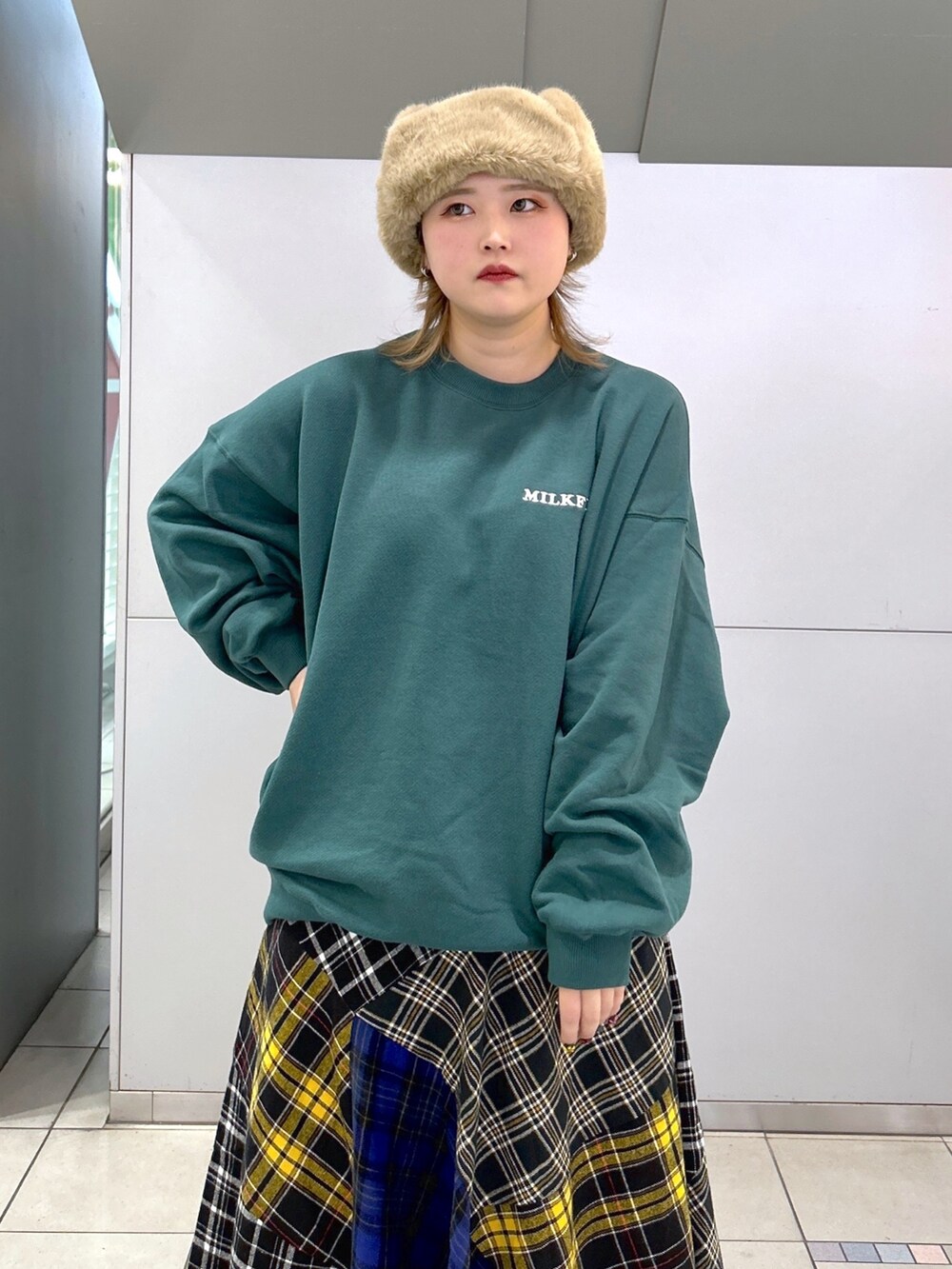 グリーン系のスウェット、グリーン系のMA-1、ブラック系のスカートを着用したレディースの冬コーディネートの5枚目の写真