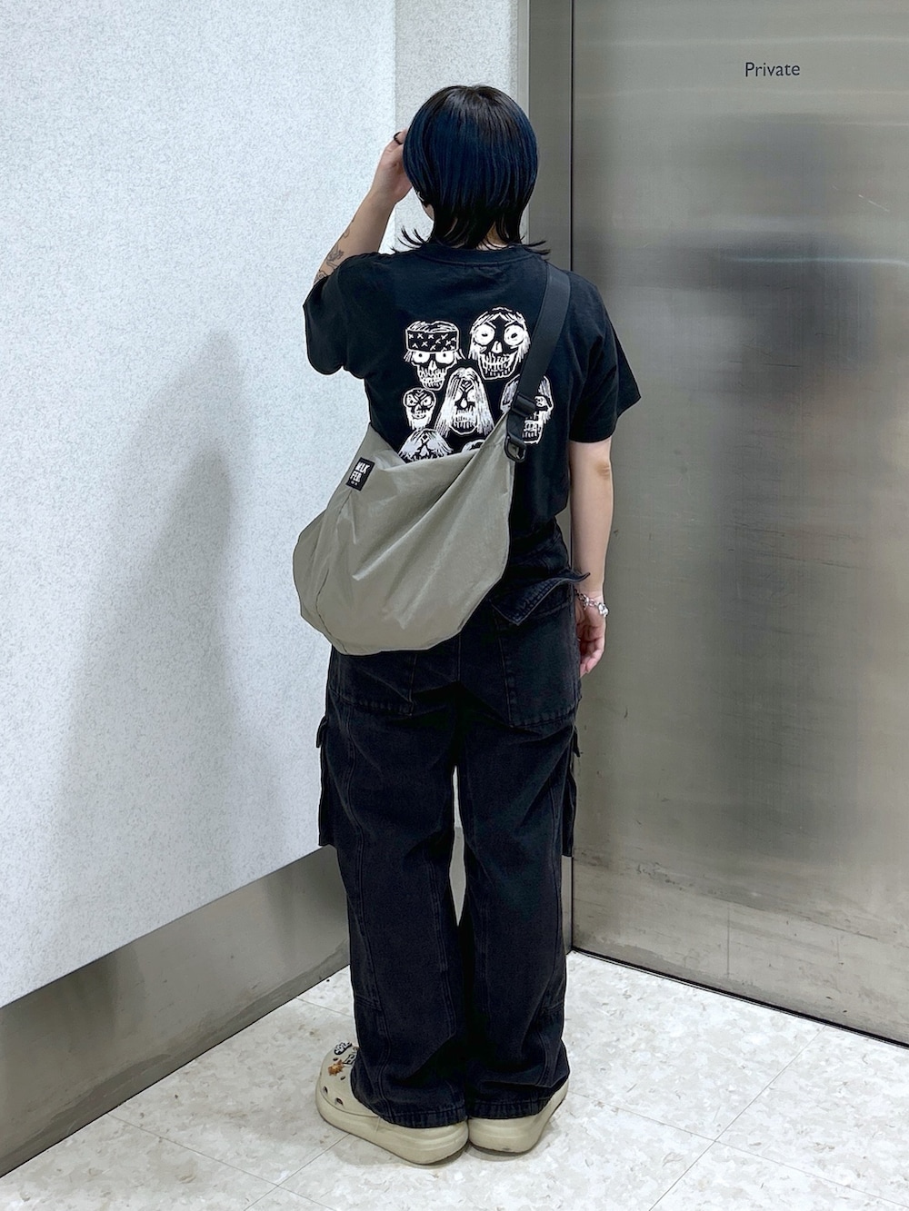 ブラック系のTシャツ/カットソー、ブラック系のカーゴパンツ、ベージュ系のショルダーバッグを着用したレディースの夏コーディネートの3枚目の写真