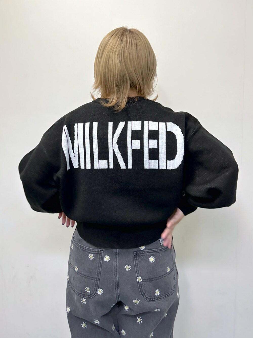 ブラック系のニット/セーター、ブラック系のデニムパンツ、レッド系のショルダーバッグを着用したレディースの秋コーディネートの3枚目の写真