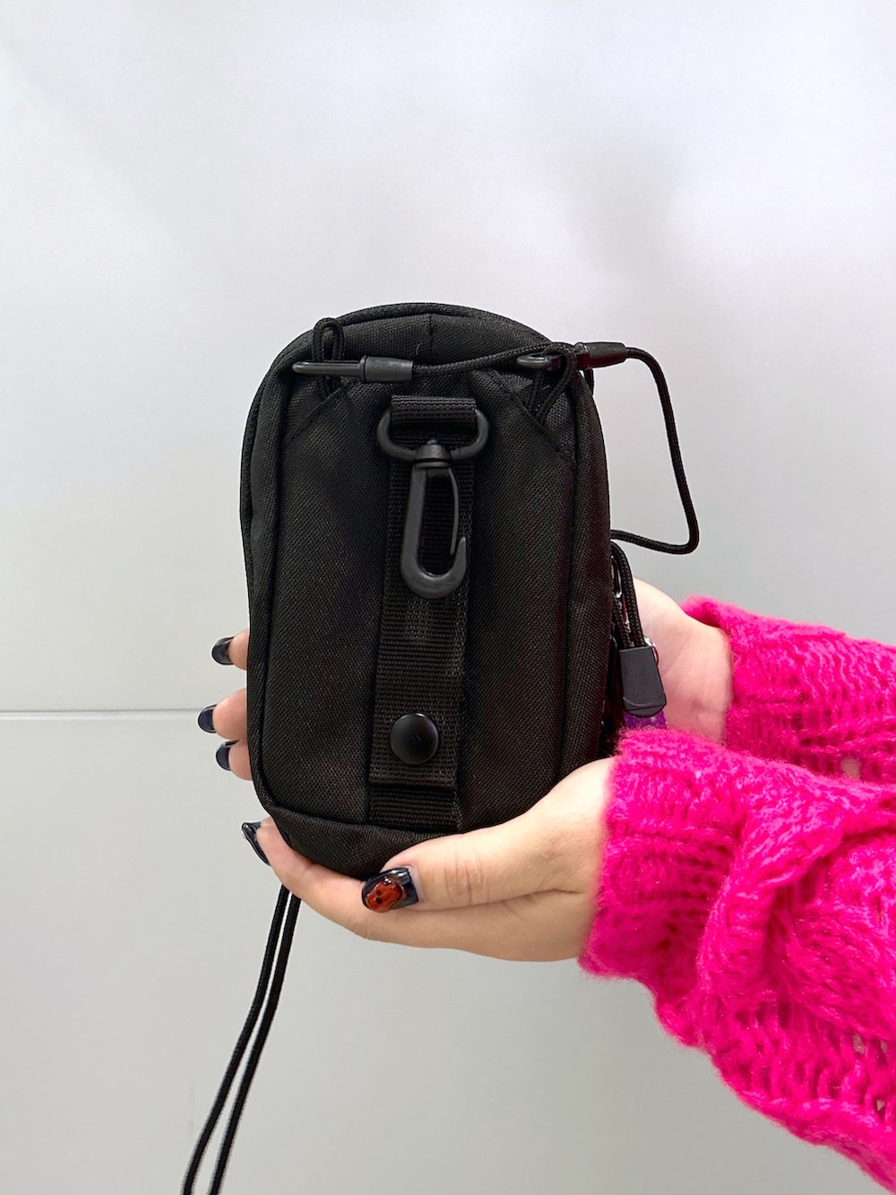 ピンク系のニット/セーター、ブラック系のサロペット/オーバーオール、パープル系のショルダーバッグを着用したレディースの秋コーディネートの5枚目の写真