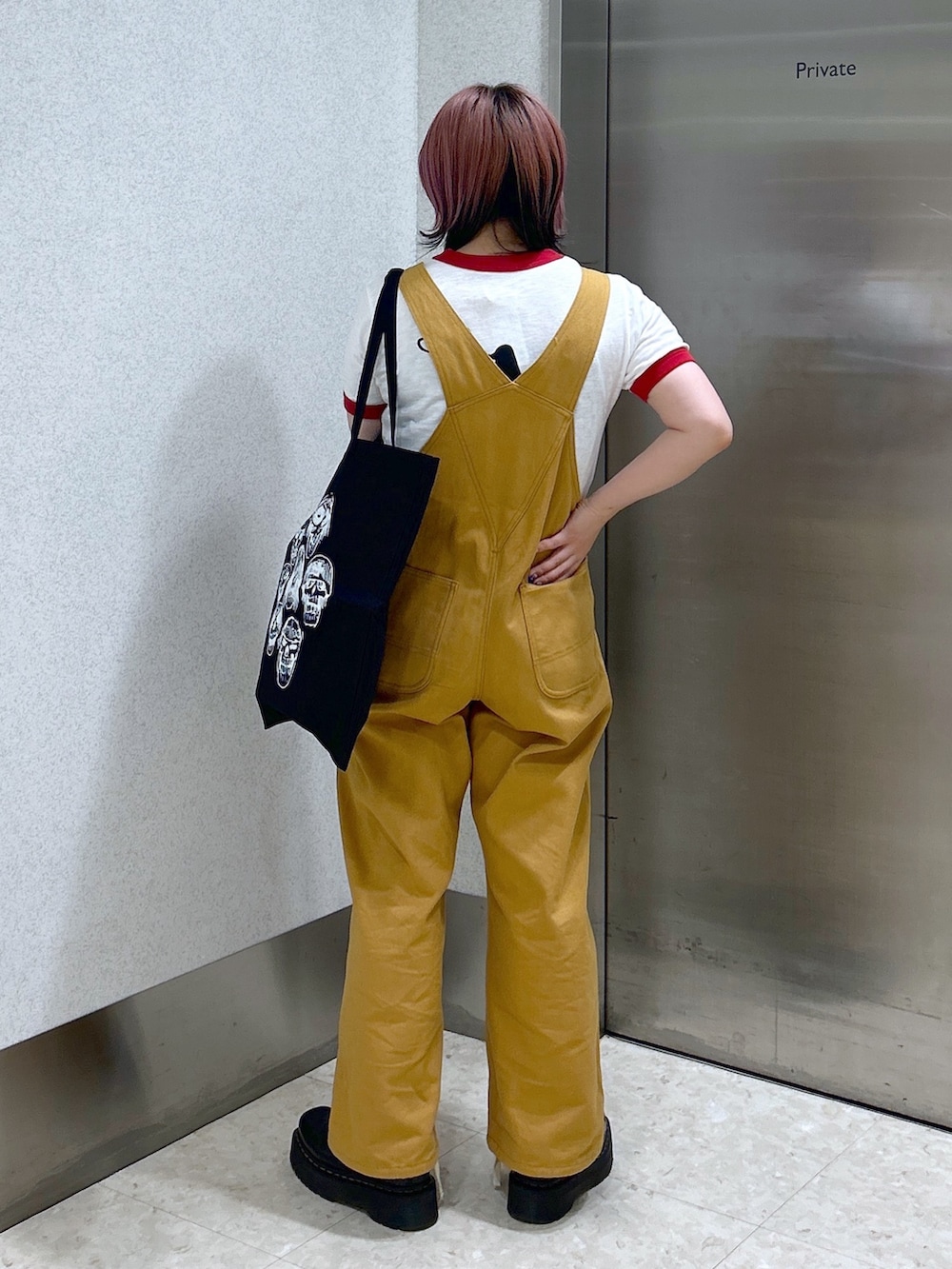 レッド系のTシャツ/カットソー、ベージュ系のサロペット/オーバーオール、ブラック系のトートバッグを着用したレディースの夏コーディネートの4枚目の写真