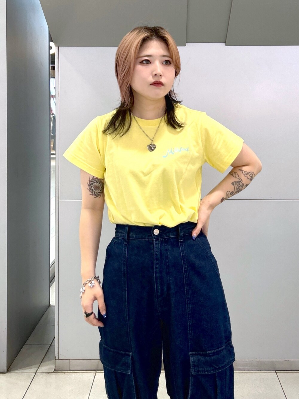 イエロー系のTシャツ/カットソー、ブラック系のキャミソール、ブラック系のブーツを着用したレディースの夏コーディネートの7枚目の写真