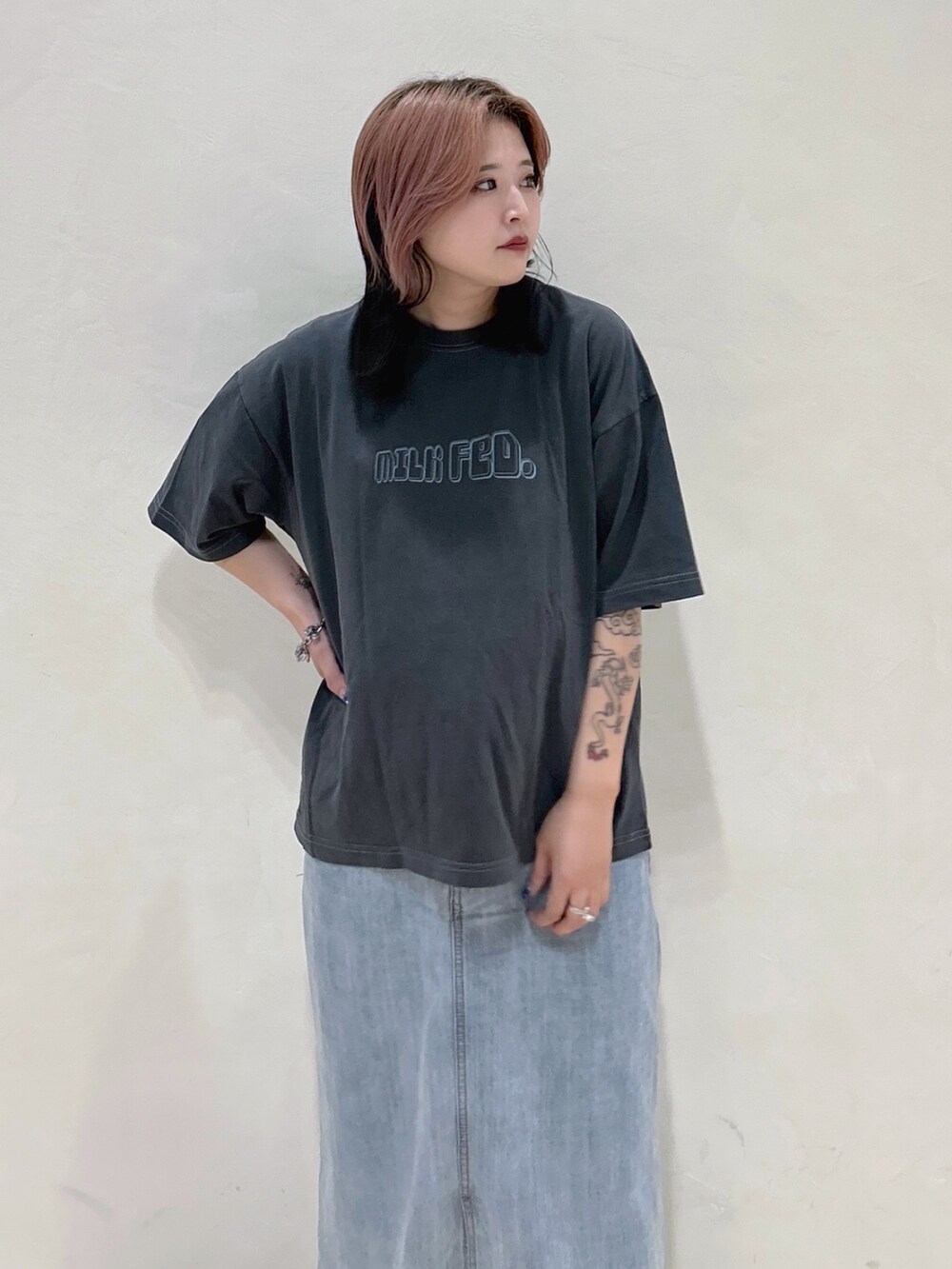 グレー系のTシャツ/カットソー、グリーン系のショルダーバッグ、ブルー系のデニムスカートを着用したレディースの夏コーディネートの4枚目の写真