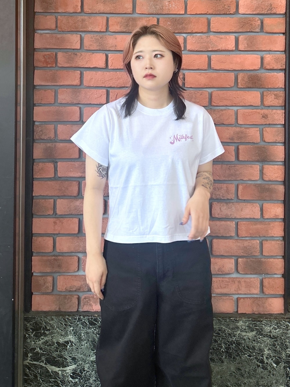 ブラック系のブーツ、ホワイト系のTシャツ/カットソー、ブラック系のデニムパンツを着用したレディースの夏コーディネートの6枚目の写真