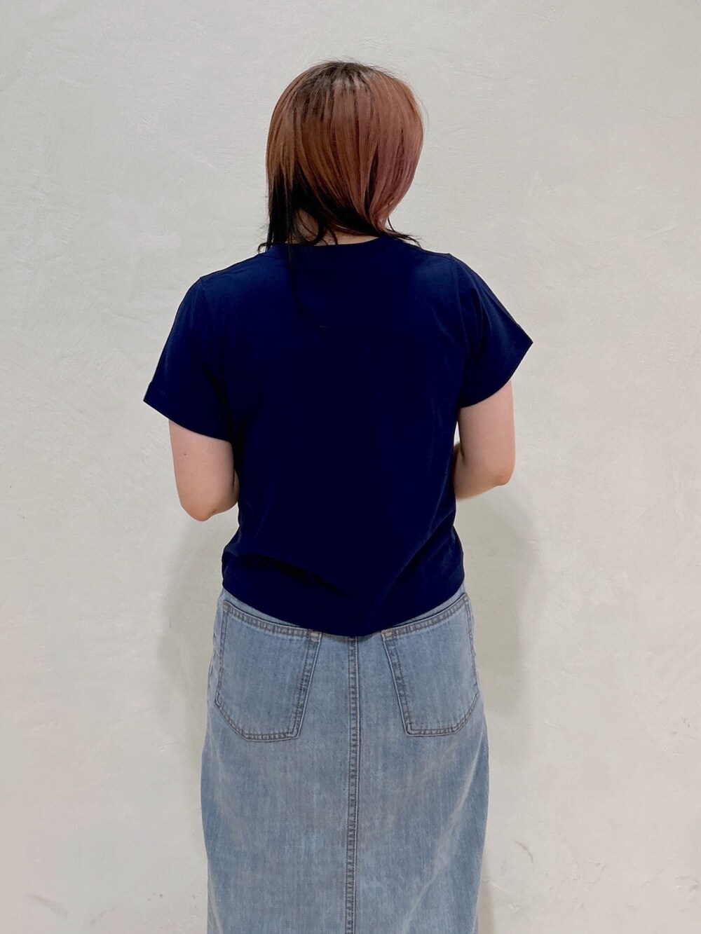 ブルー系のTシャツ/カットソー、ブルー系のデニムスカート、ホワイト系のトートバッグを着用したレディースの夏コーディネートの6枚目の写真