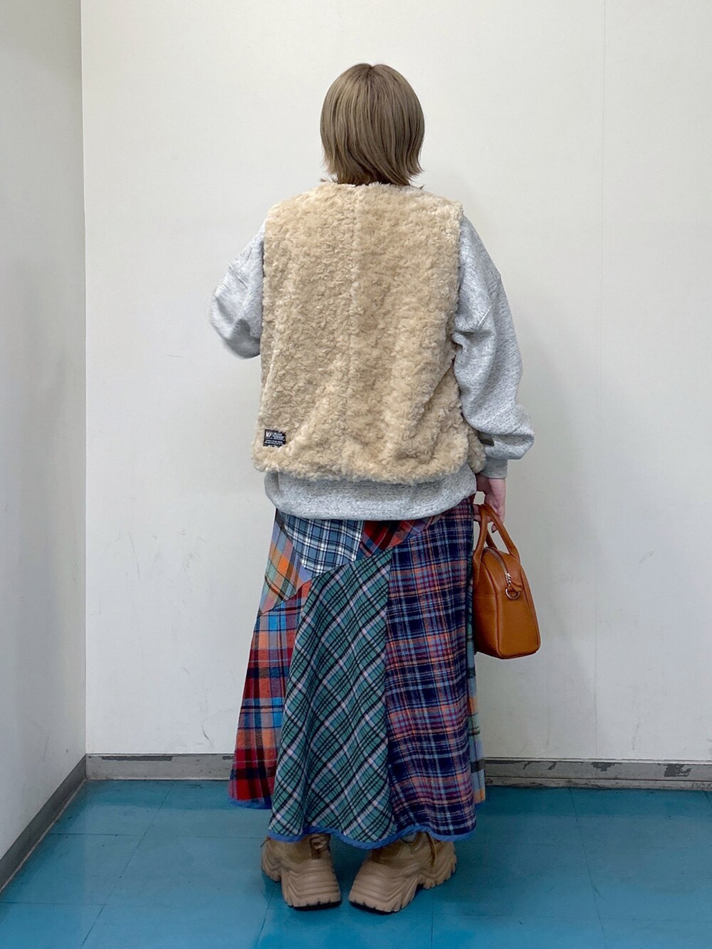 ホワイト系のベスト、その他のスウェット、グリーン系のスカートを着用したレディースの秋コーディネートの2枚目の写真