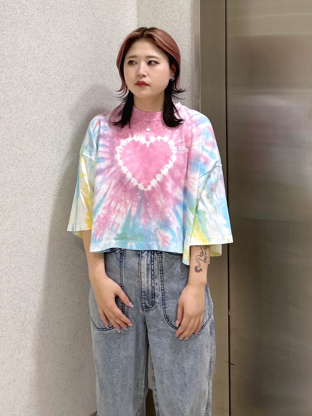 ブルー系のデニムパンツ、ブラック系のショルダーバッグ、ベージュ系のサンダルを着用したレディースの夏コーディネートの4枚目の写真