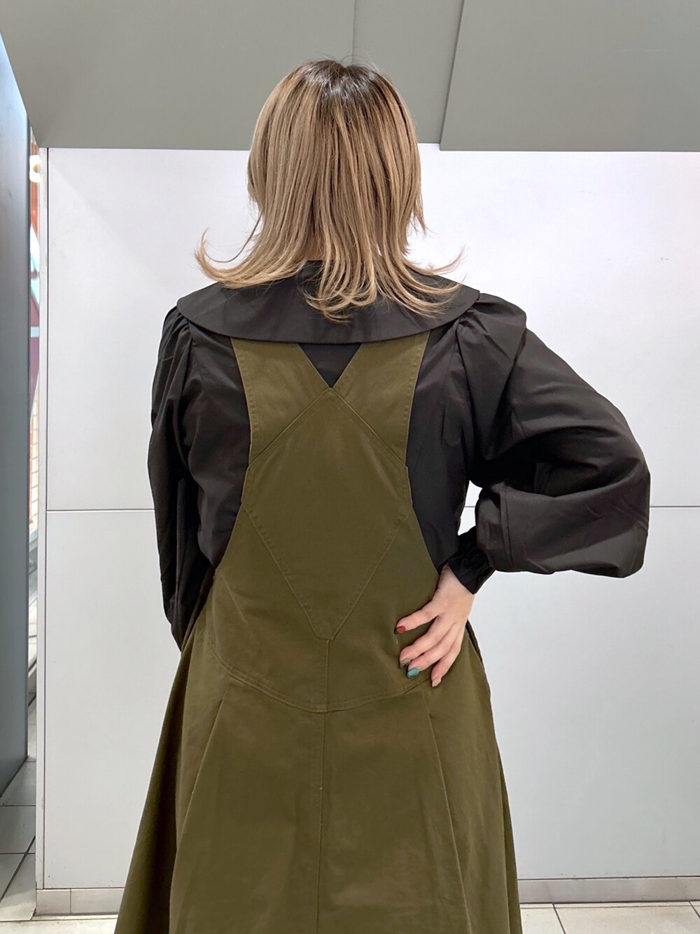 ブラック系のシャツ/ブラウス、グリーン系のジャンパースカート、ブラック系のブーツを着用したレディースの冬コーディネートの4枚目の写真