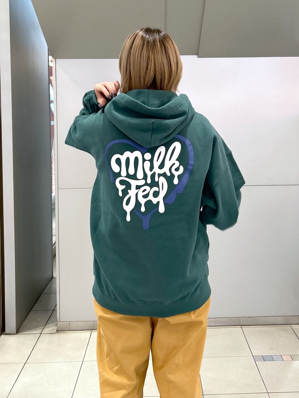 グリーン系のパーカー、ブラック系のTシャツ/カットソー、ベージュ系のサロペット/オーバーオールを着用したレディースの冬コーディネートの6枚目の写真