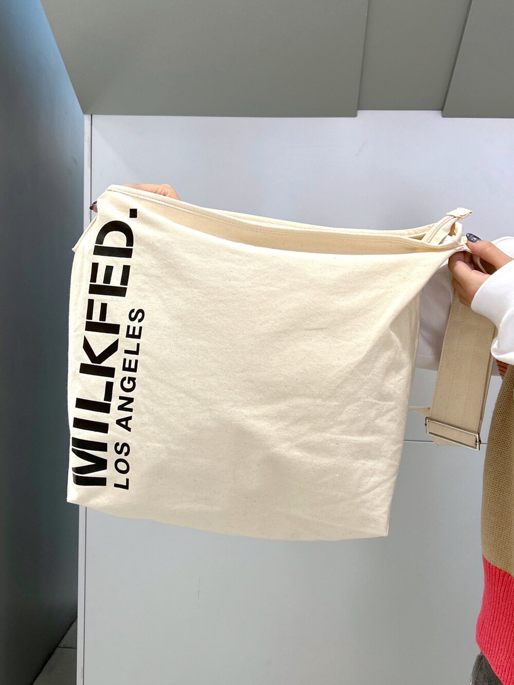 ベージュ系のベスト、ホワイト系のTシャツ/カットソー、ホワイト系のショルダーバッグを着用したレディースの秋コーディネートの4枚目の写真