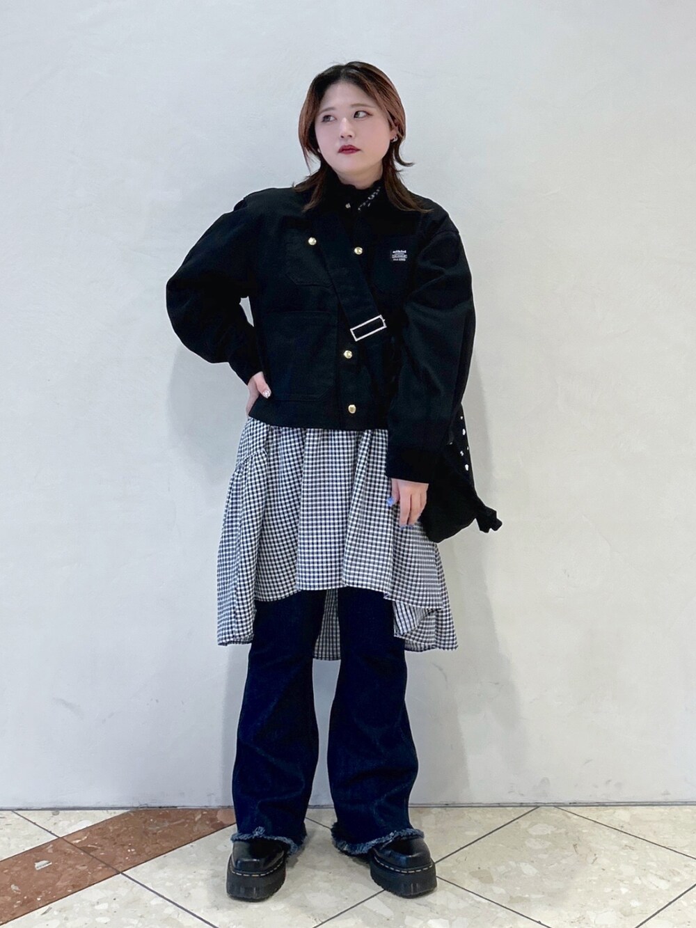 ブルー系のデニムパンツ、ブラック系のカバーオール、ブラック系のワンピースを着用したレディースの春コーディネートの3枚目の写真