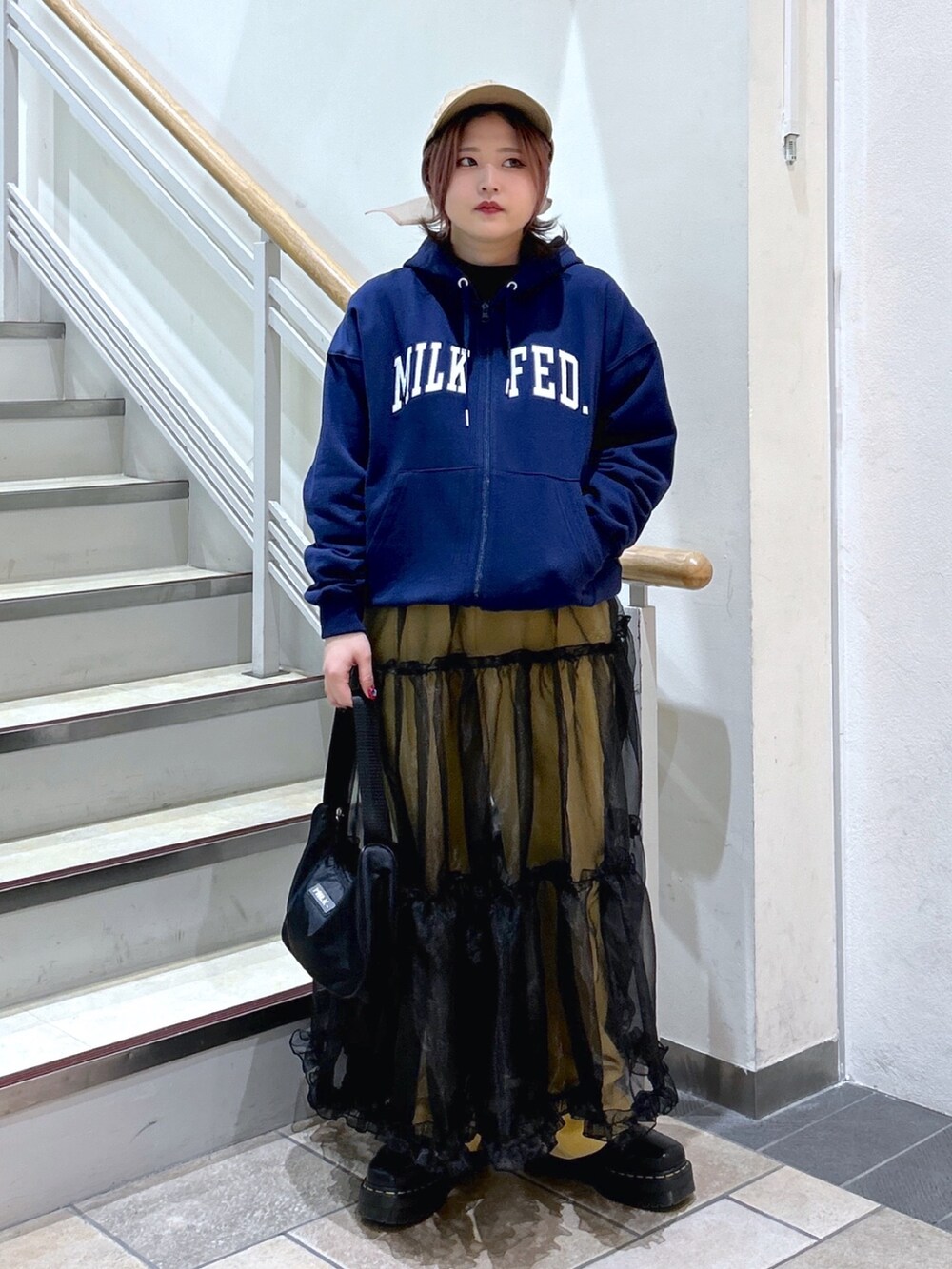 ブルー系のパーカー、イエロー系のその他パンツ、ブラック系のハンドバッグを着用したレディースの冬コーディネートの2枚目の写真