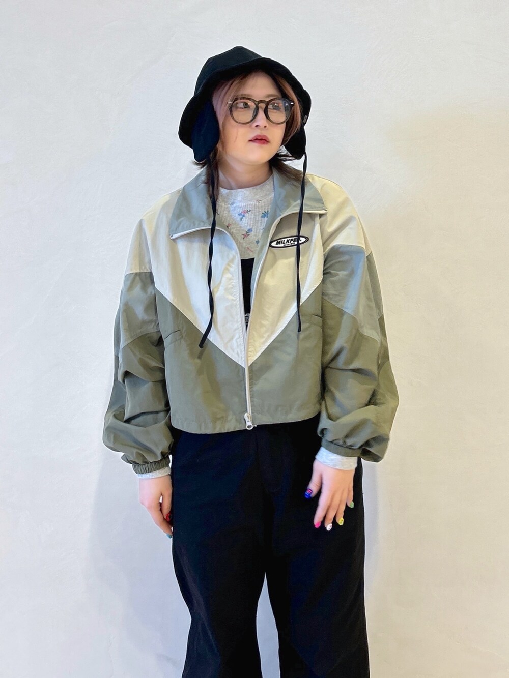 グレー系のTシャツ/カットソー、ベージュ系のナイロンジャケット、ブラック系のサロペット/オーバーオールを着用したレディースの春コーディネートの6枚目の写真