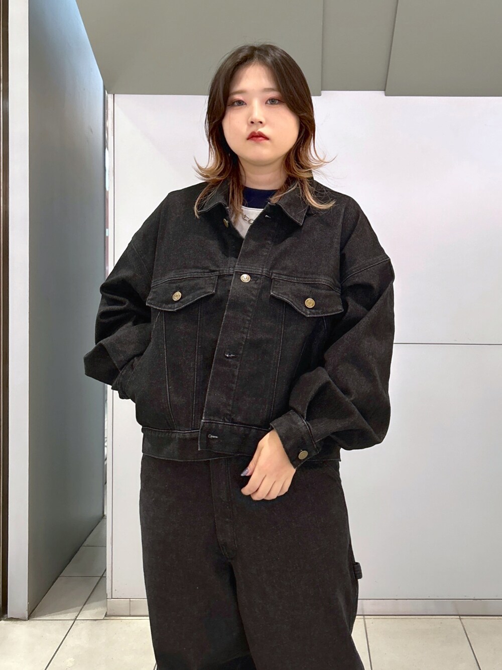 ブラック系のデニムジャケット、ブラック系のサロペット/オーバーオール、ピンク系のハンドバッグを着用したレディースの秋コーディネートの4枚目の写真