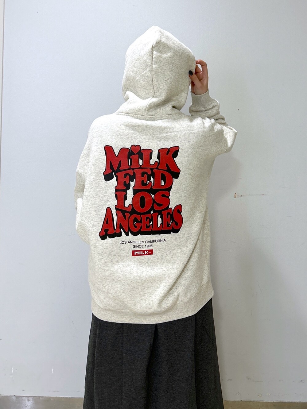 ブルー系のショルダーバッグ、ベージュ系のパーカー、グレー系のワンピースを着用したレディースの冬コーディネートの3枚目の写真