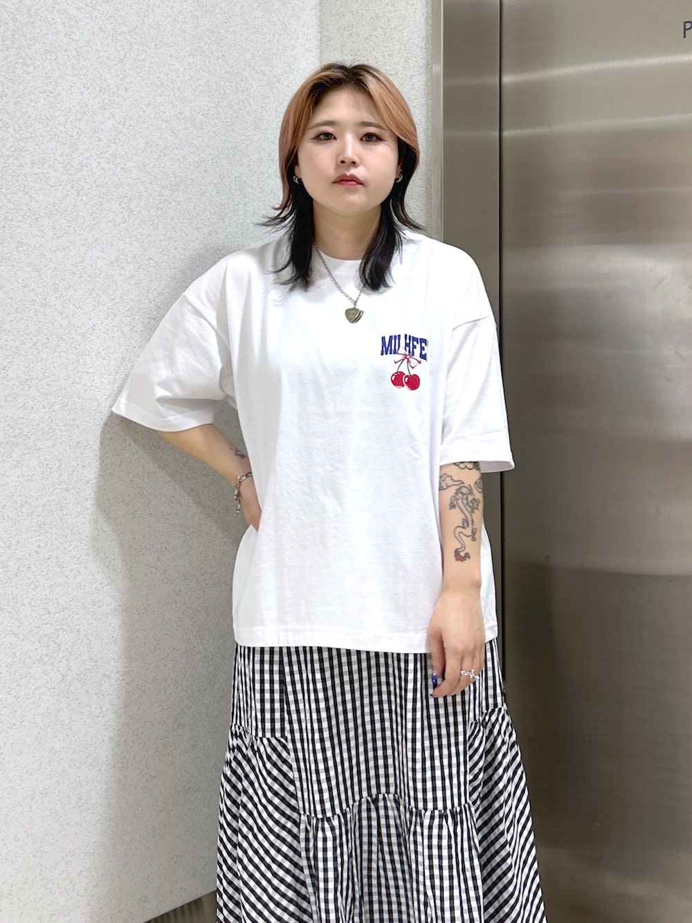 ホワイト系のTシャツ/カットソー、ブラック系のスカート、ブルー系のショルダーバッグを着用したレディースの夏コーディネートの4枚目の写真