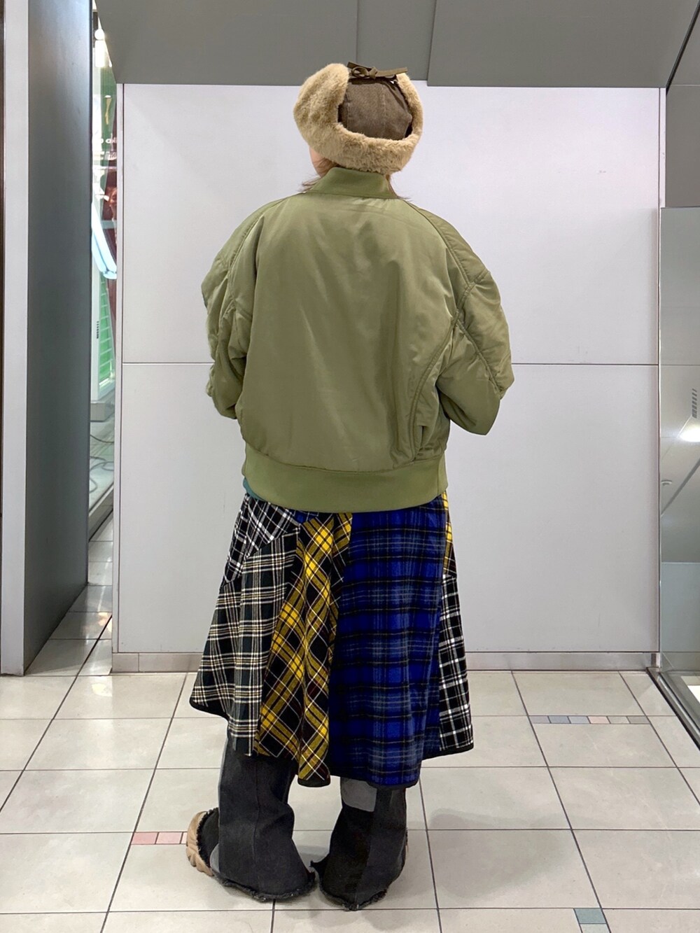 グリーン系のスウェット、グリーン系のMA-1、ブラック系のスカートを着用したレディースの冬コーディネートの3枚目の写真