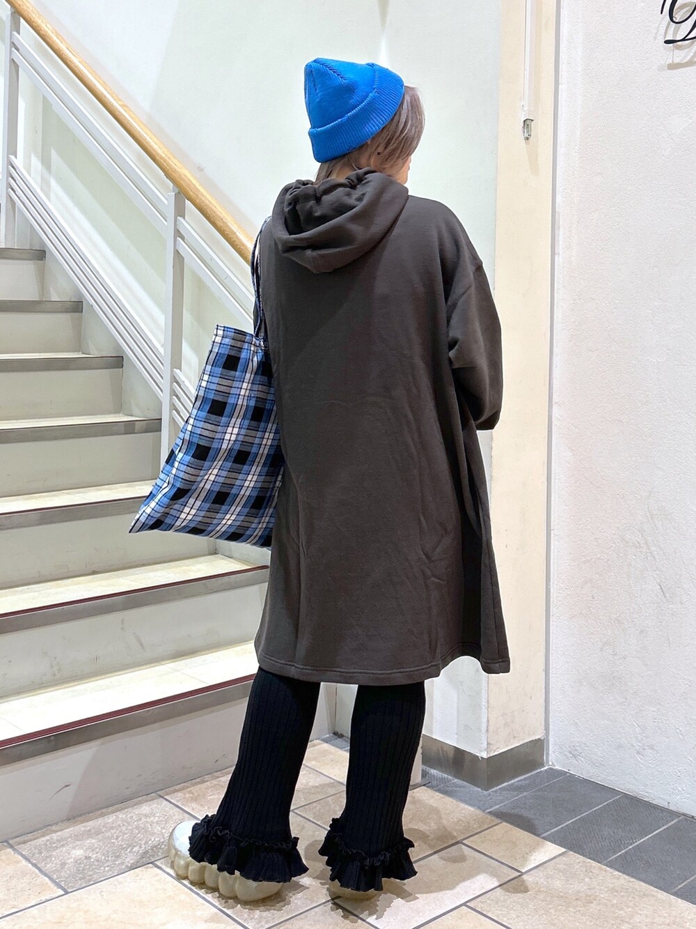 グレー系のワンピース、ブルー系のトートバッグ、ブラック系のその他パンツを着用したレディースの秋コーディネートの3枚目の写真