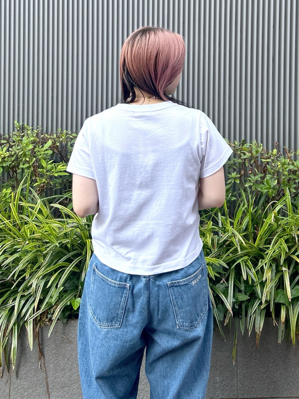 ブルー系のデニムパンツ、ホワイト系のTシャツ/カットソー、ベージュ系のサンダルを着用したレディースの夏コーディネートの6枚目の写真