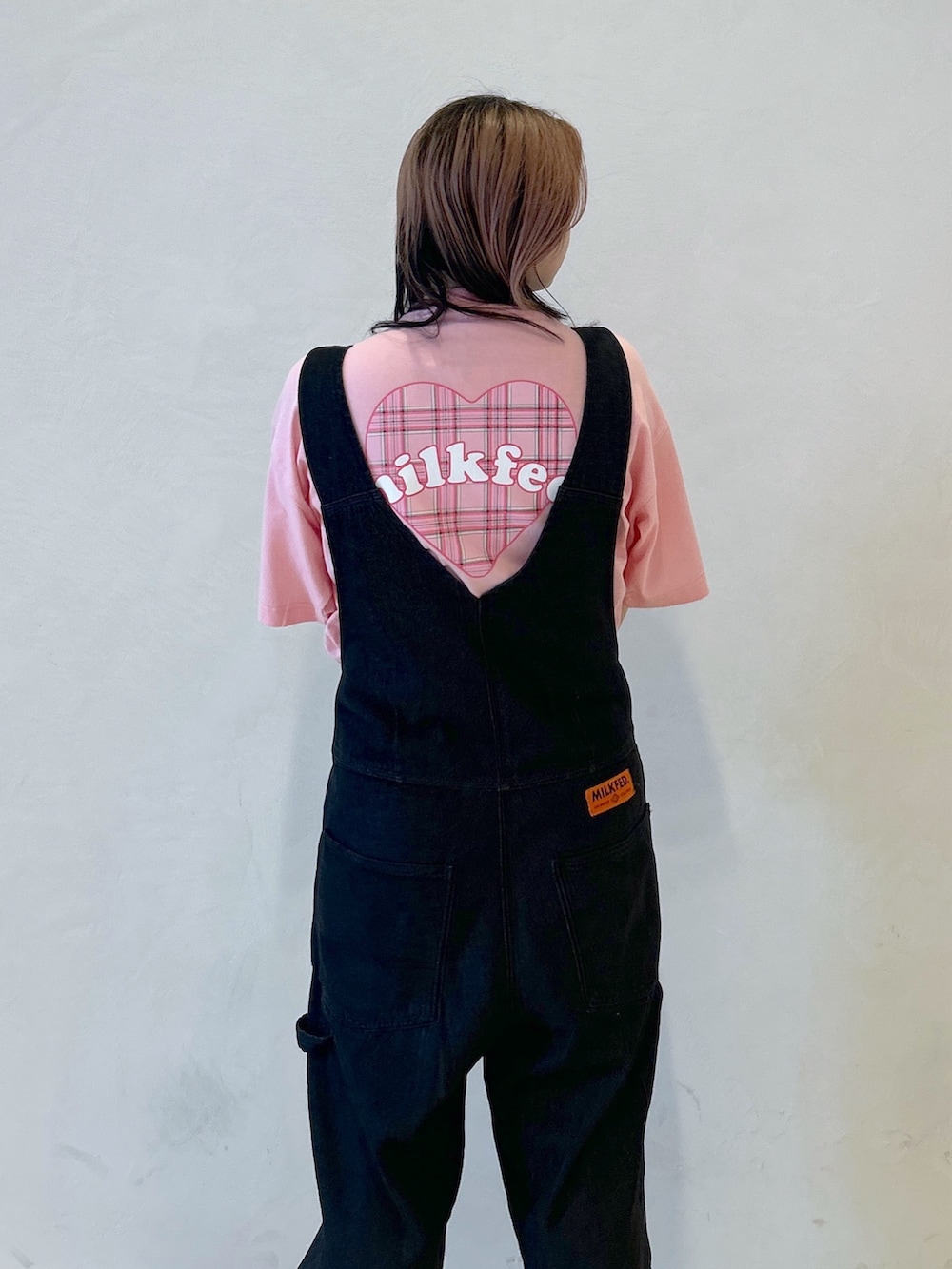 ピンク系のTシャツ/カットソー、ブラック系のショルダーバッグ、ブラック系のサロペット/オーバーオールを着用したレディースの夏コーディネートの5枚目の写真