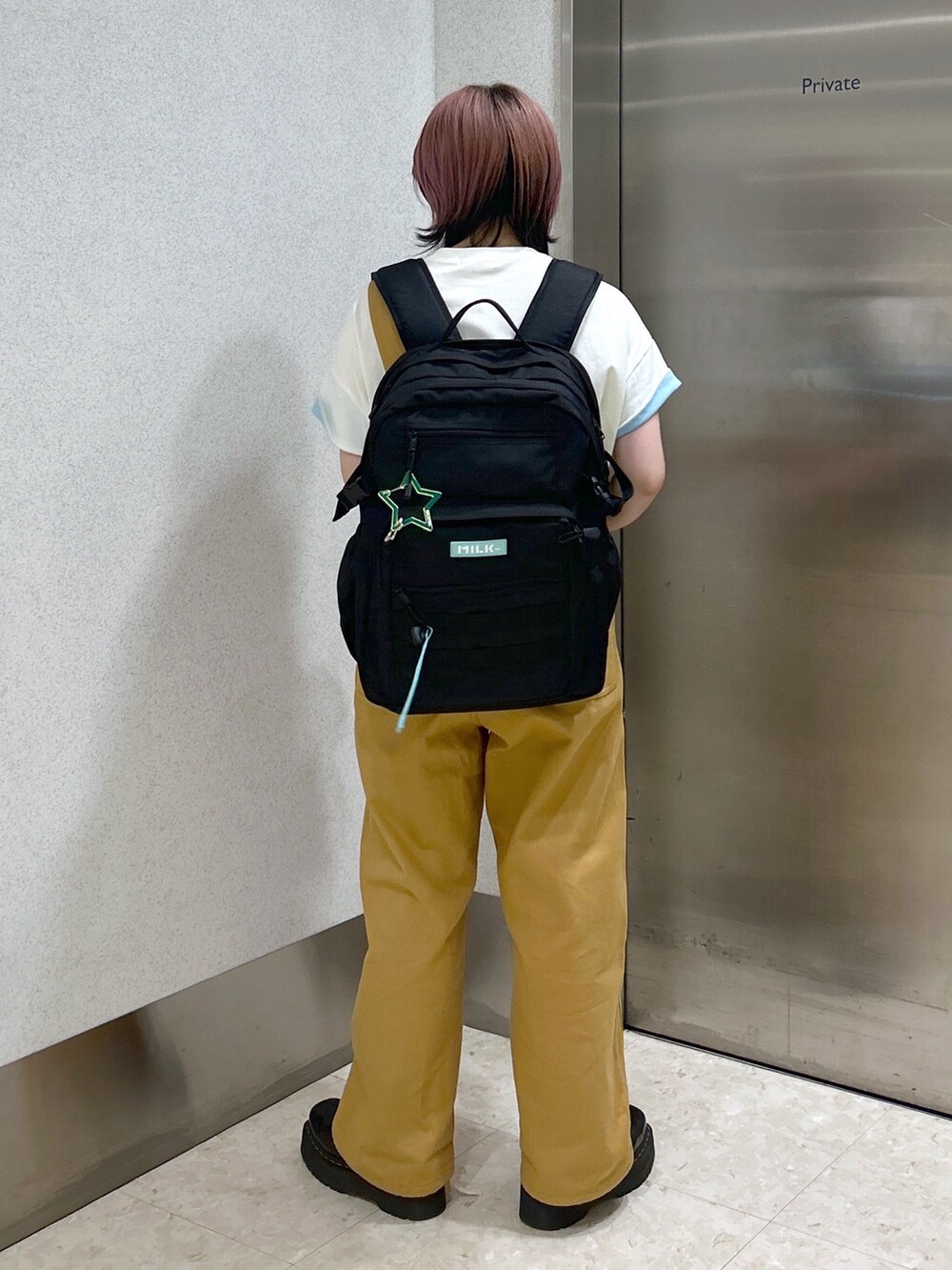 ベージュ系のサロペット/オーバーオール、ホワイト系のTシャツ/カットソー、ブラック系のブーツを着用したレディースの夏コーディネートの5枚目の写真