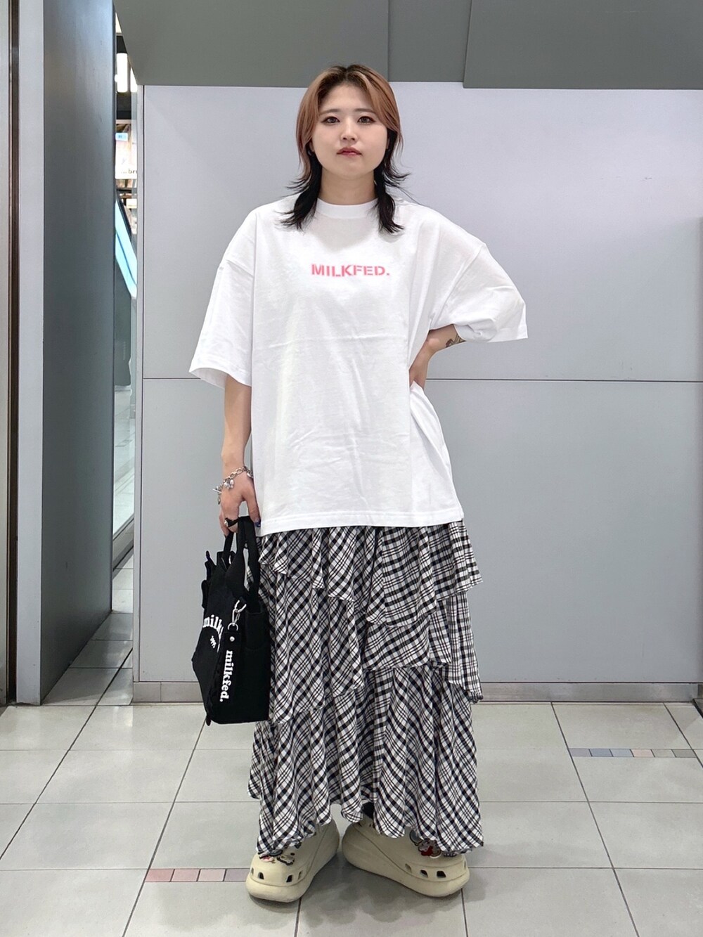ホワイト系のTシャツ/カットソー、ブラック系のスカート、ベージュ系のサンダルを着用したレディースの夏コーディネートの2枚目の写真