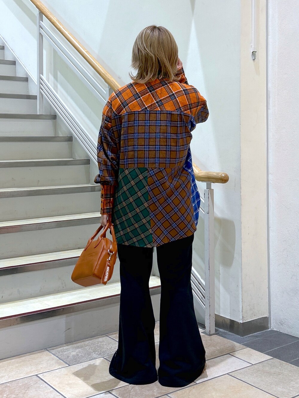 ブラウン系のシャツ/ブラウス、ブラウン系のボストンバッグ、ブラック系のスウェットパンツを着用したレディースの秋コーディネートの3枚目の写真