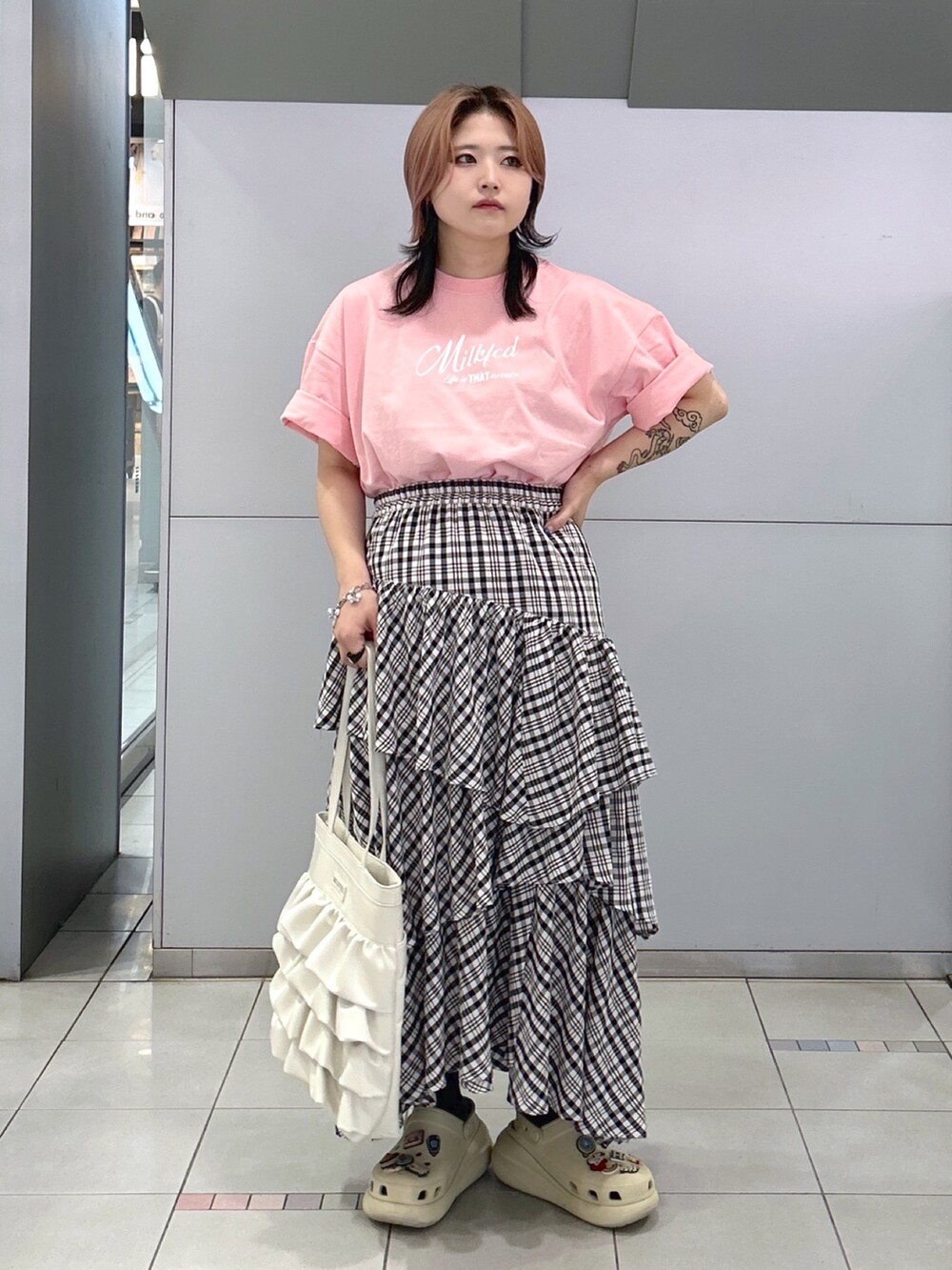 ピンク系のTシャツ/カットソー、ブラック系のスカート、ホワイト系のトートバッグを着用したレディースの夏コーディネートの4枚目の写真