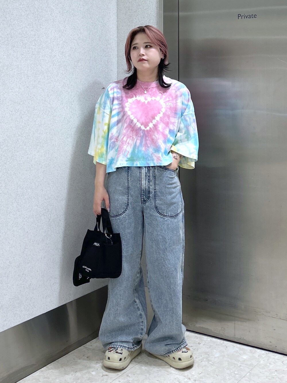ブルー系のデニムパンツ、ブラック系のショルダーバッグ、ベージュ系のサンダルを着用したレディースの夏コーディネートの2枚目の写真